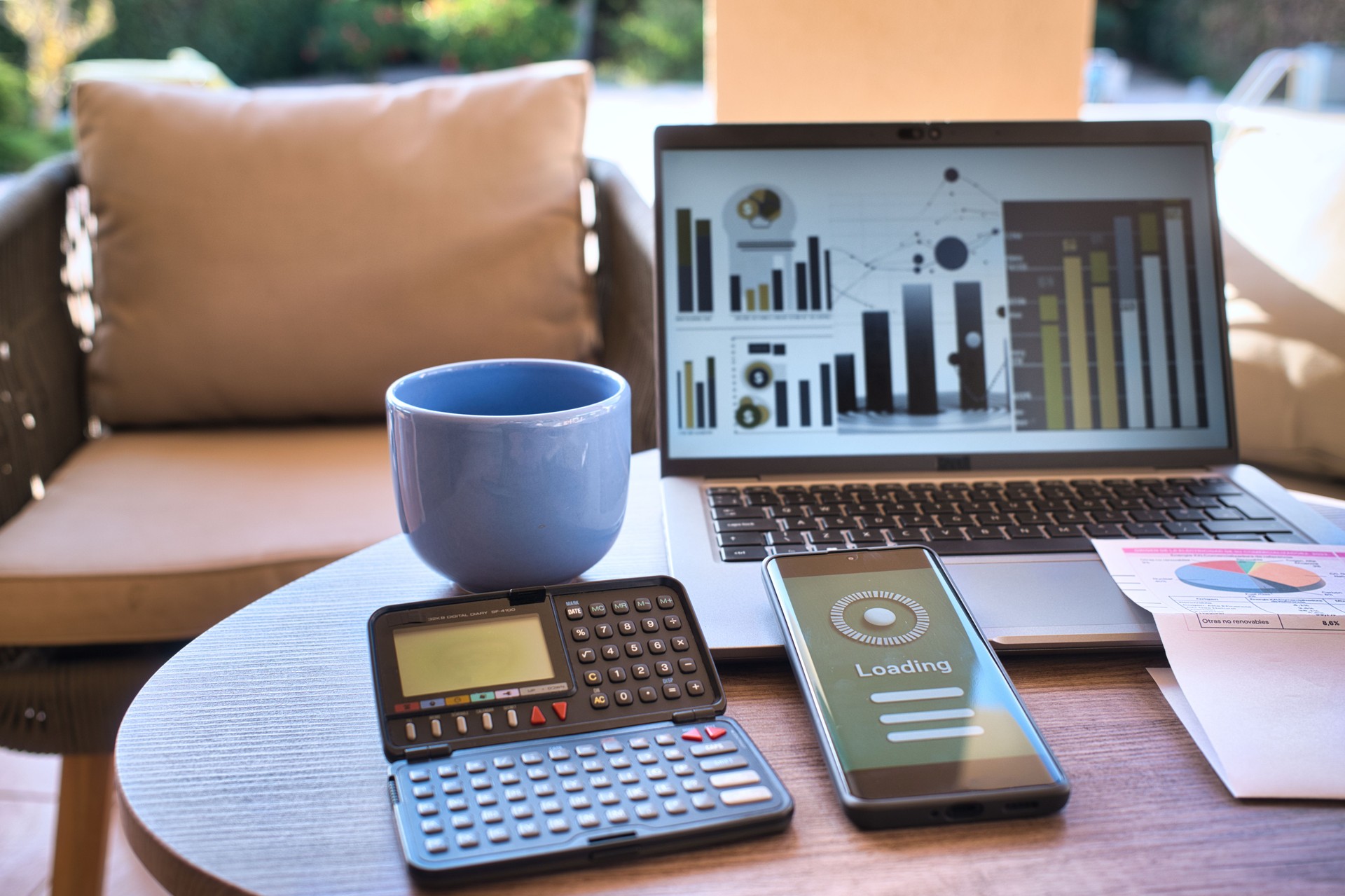 Digital finance management with smartphone payment loading, invoice, laptop, and calculator on sunny terrace. With copy space